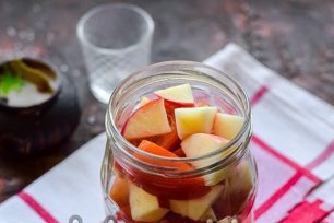 doe kruiden, tomaten en appels in een voorbereide pot